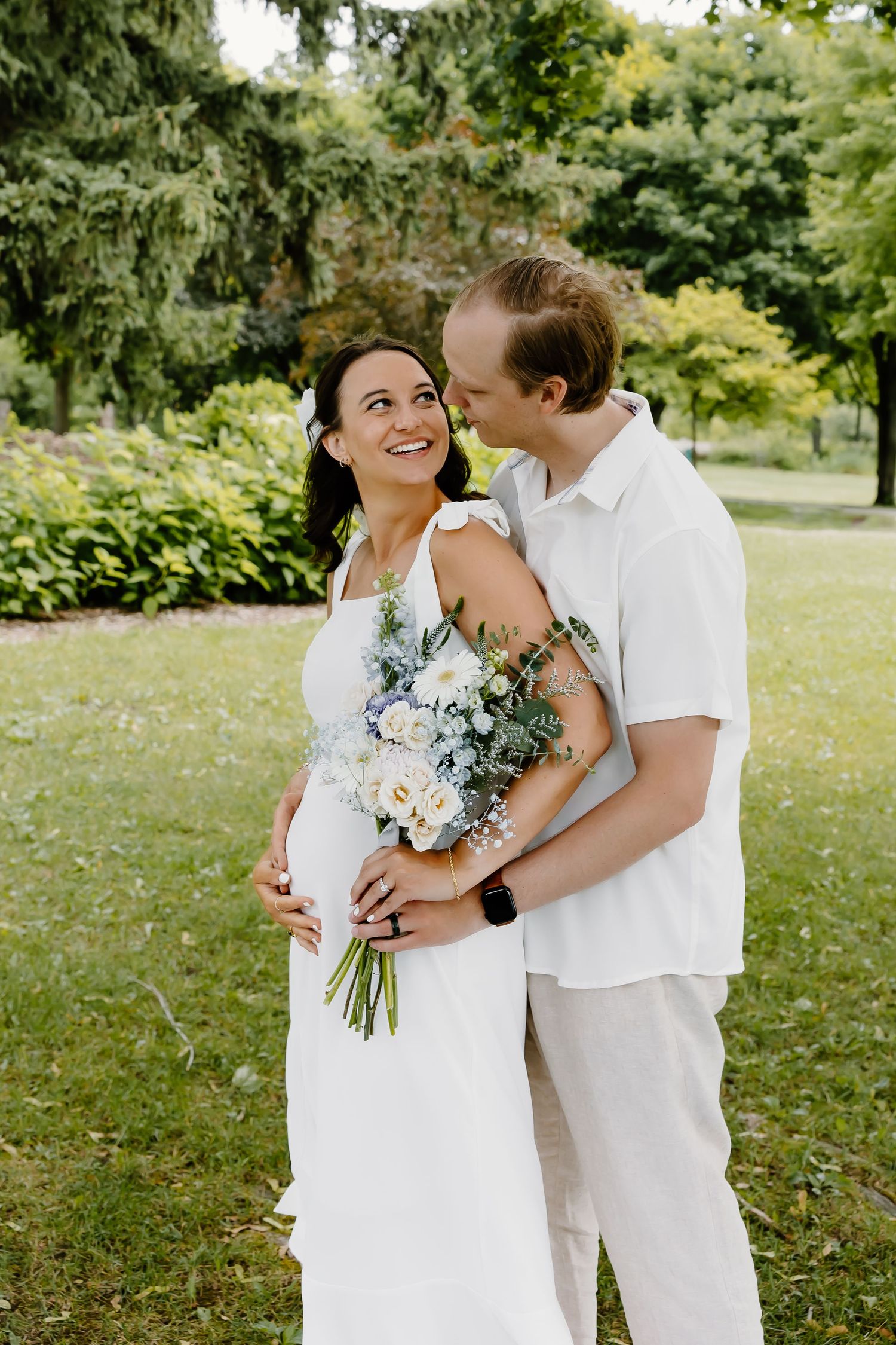 Joyful maternity photography session in a green summer garden.