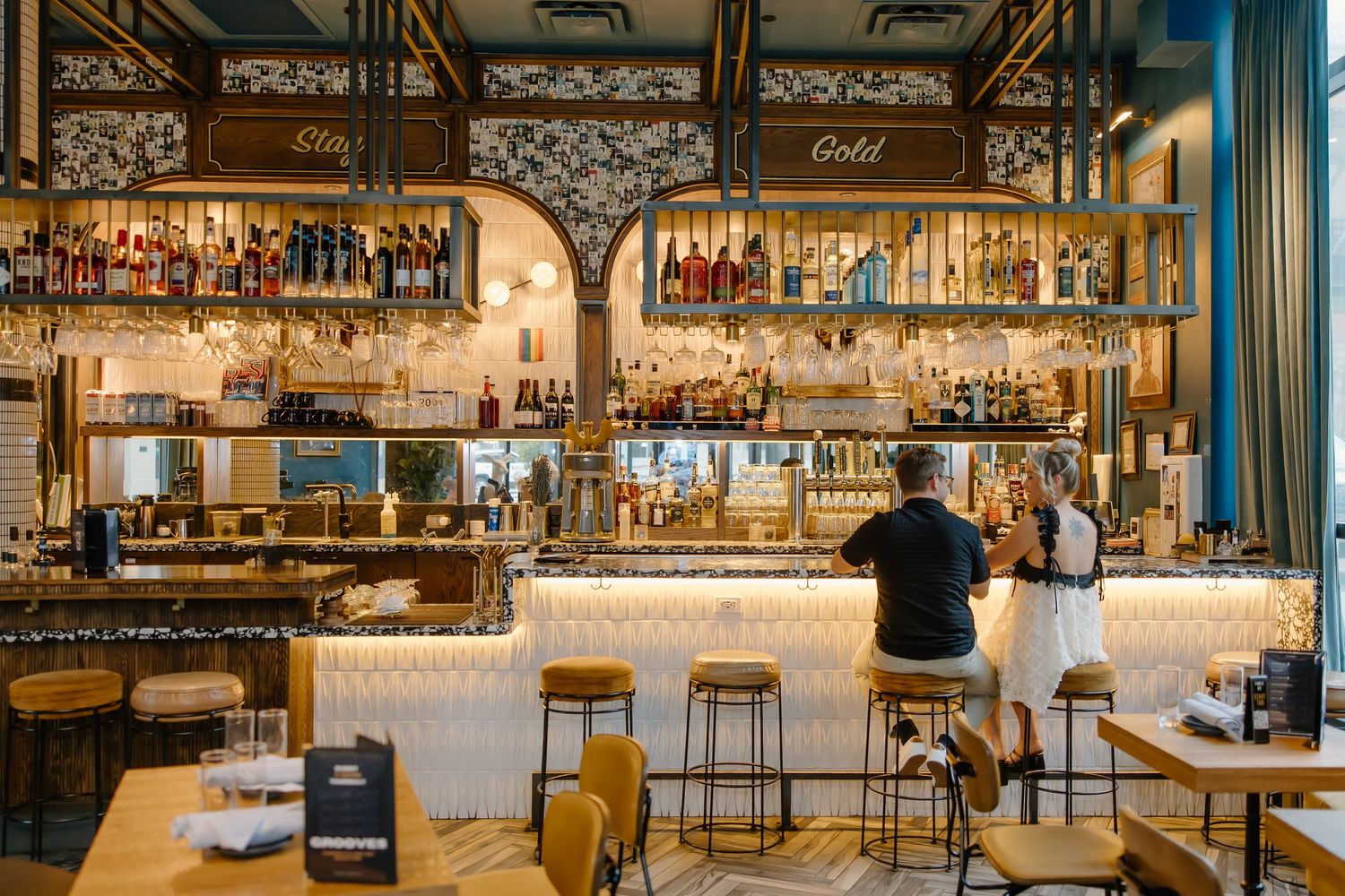 Modern restaurant bar interior with industrial design elements and white counter.
