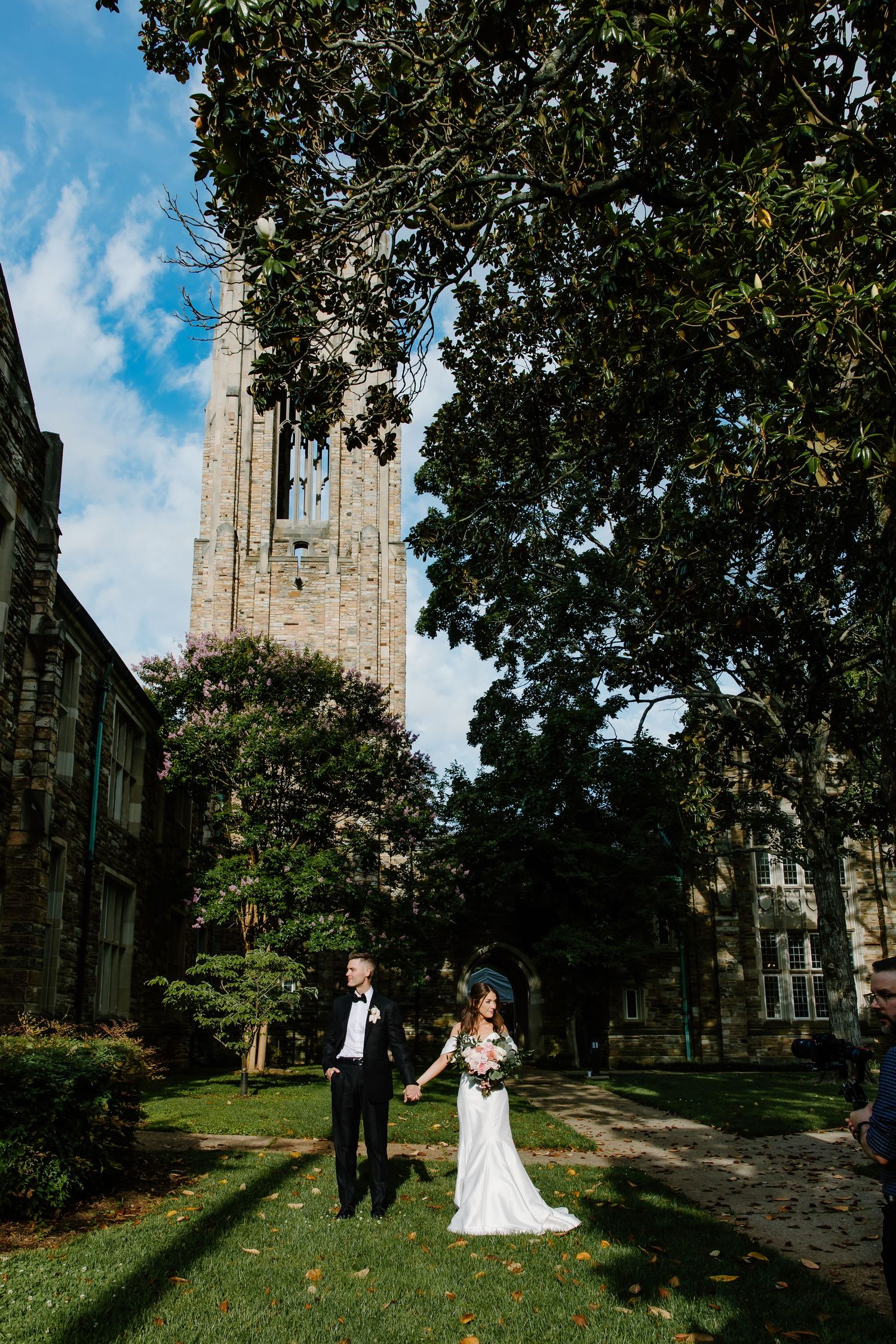 Gothic church tower provides dramatic backdrop for wedding photography.