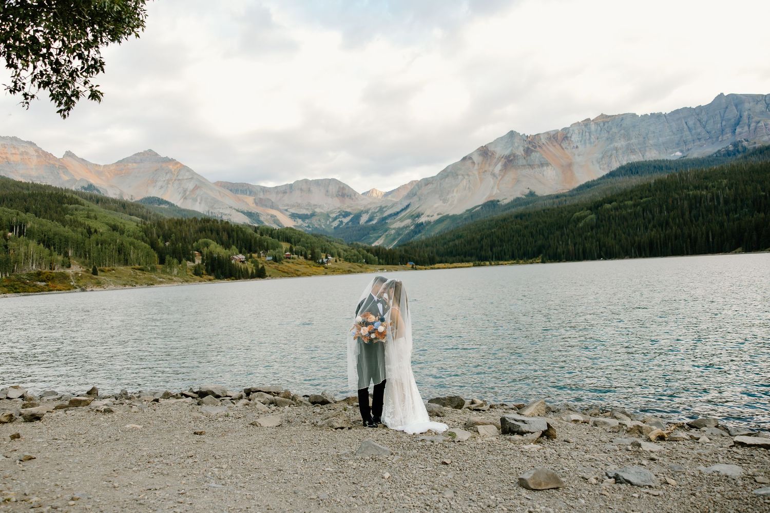 A scenic mountain lake surrounded by rugged peaks and evergreen forest in a serene wilderness setting.