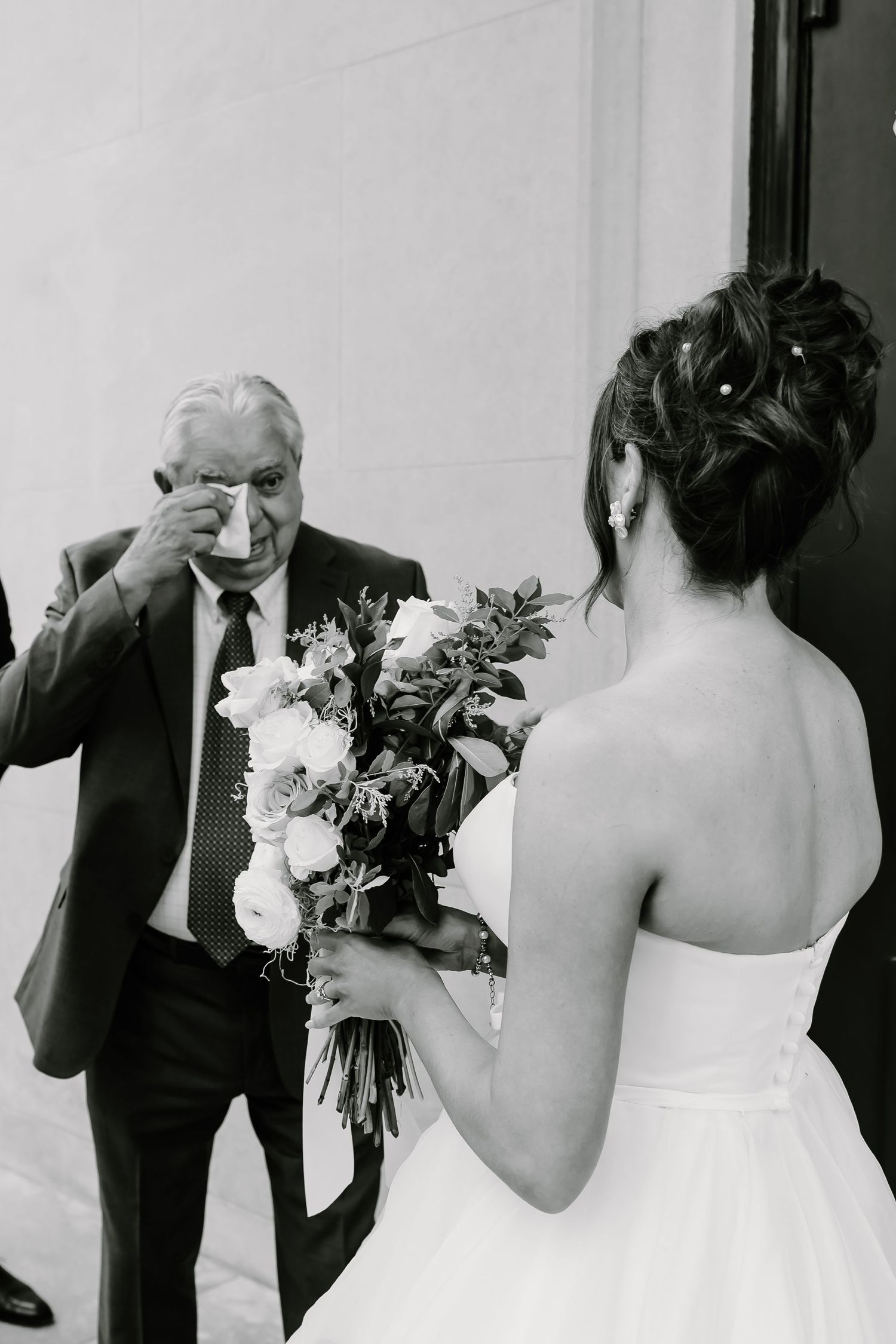 Emotional black and white moment captured during first look between bride and wedding guest.