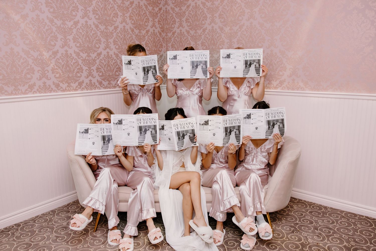 Wedding party members sit together looking at photos during preparation time.