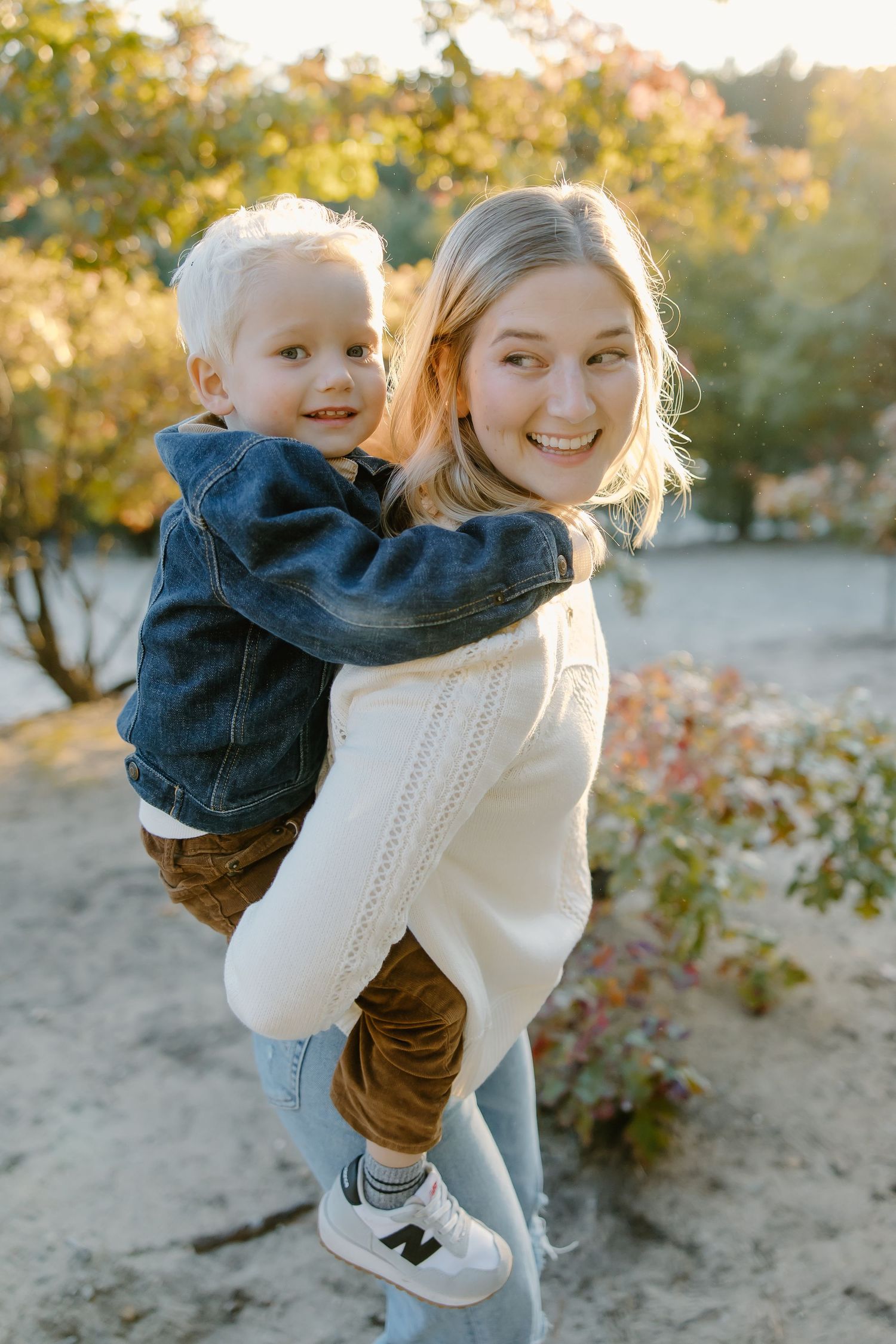 Playful moments captured during outdoor family photoshoot in fall setting.