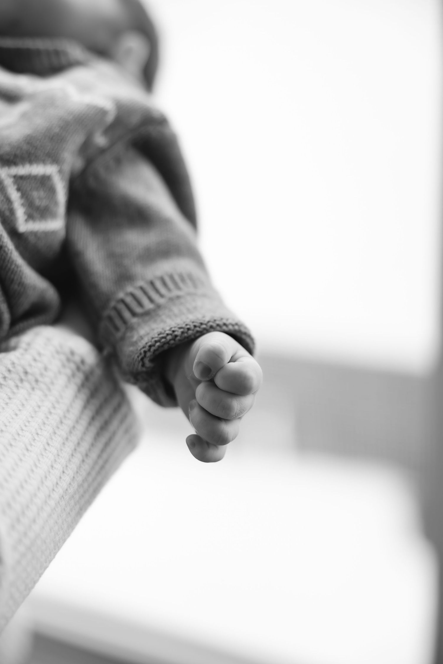 Close-up black and white image of tiny baby toes and feet in soft focus.