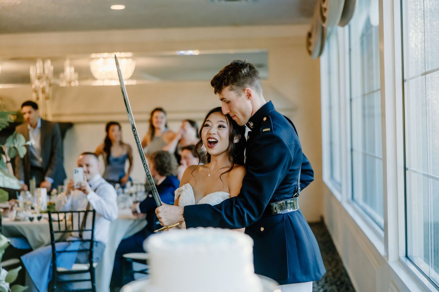 Wedding reception celebration with guests in bright indoor venue.