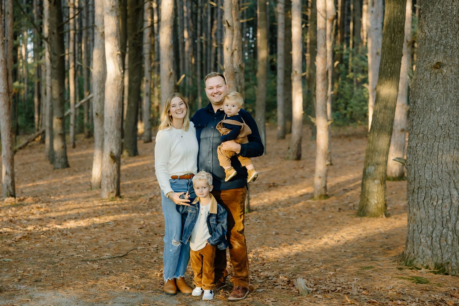 People strolling along a wooded path during golden hour.