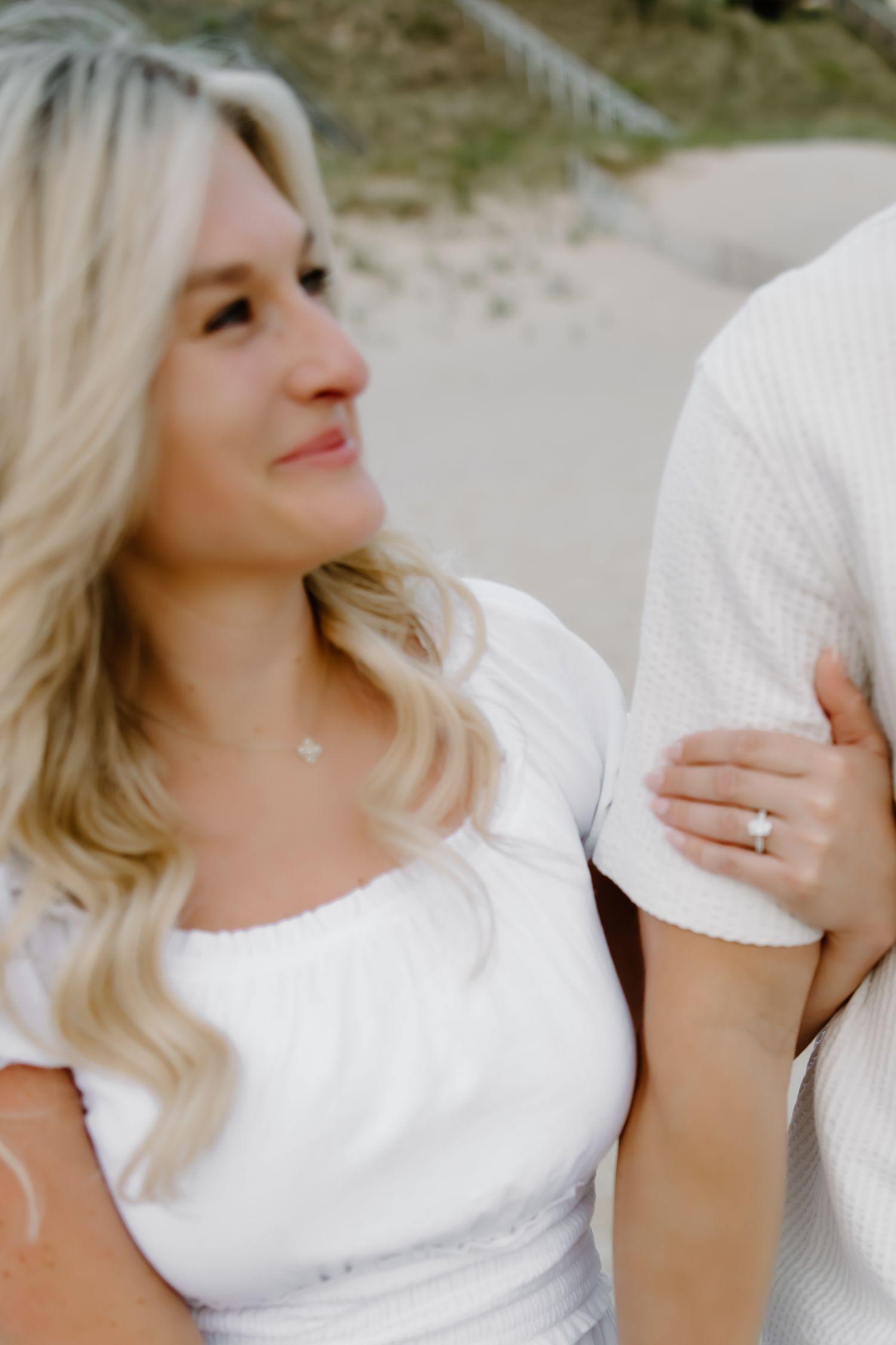 Romantic beach portrait in white outfits with soft lighting.