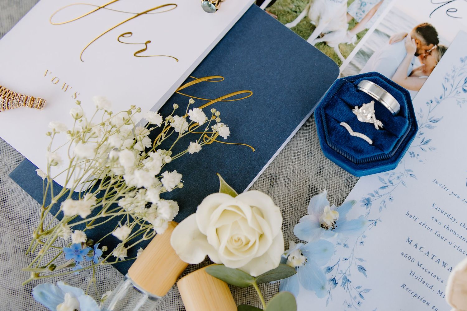 Wedding stationery in navy and white with gold accents and floral details.