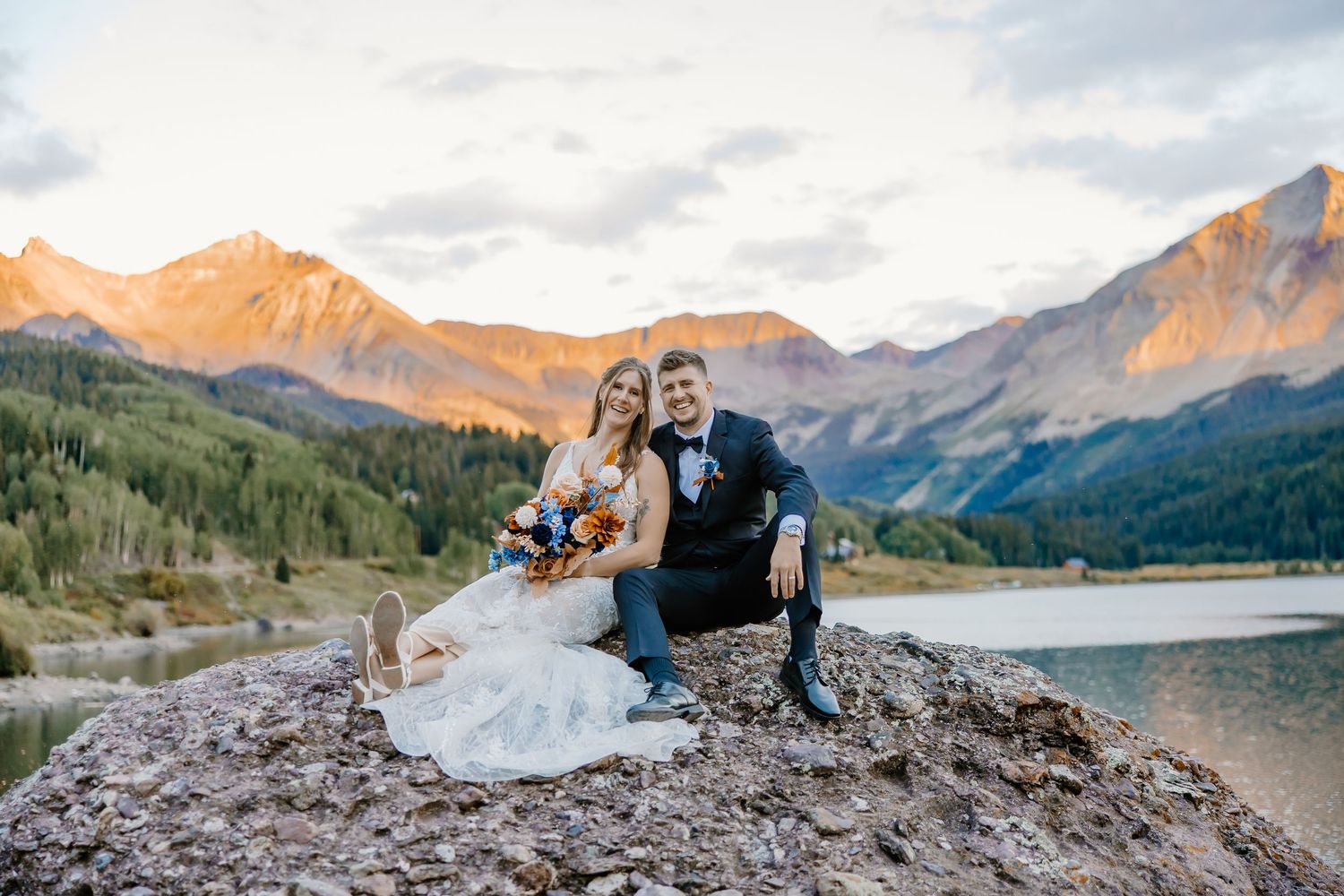 Romantic sunset moment captured on a rocky overlook with mountain lake and peaks in the background.