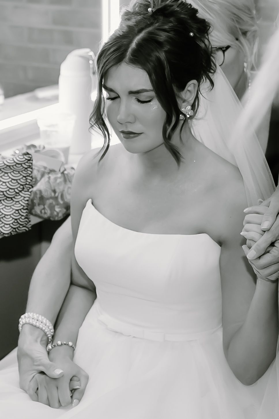 Elegant white wedding dress details captured in black and white photography.