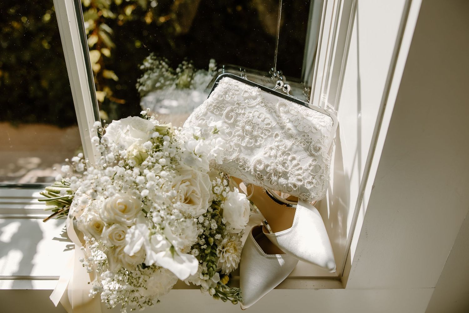 White floral arrangements and wedding details in natural window light.