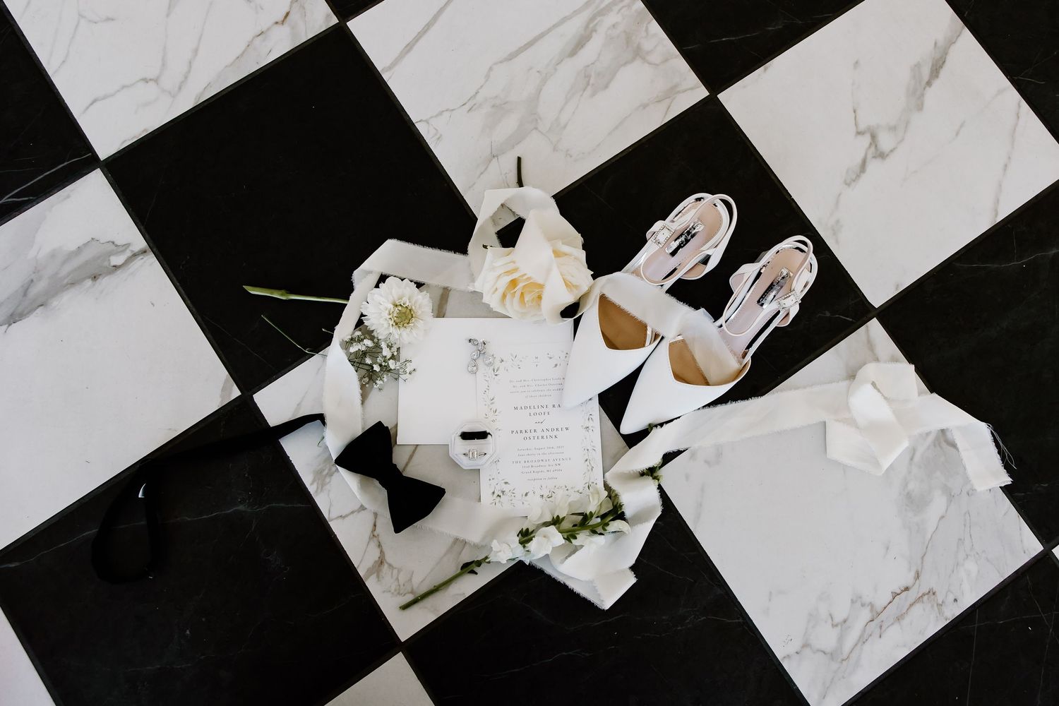 Black and white checkered pattern with scattered paper elements creating an artistic composition.