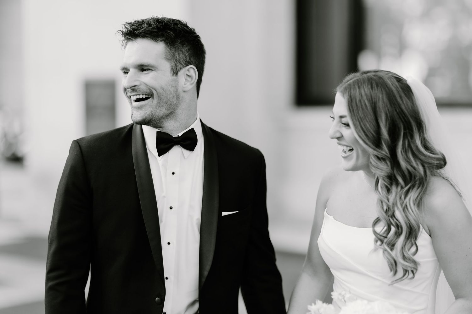 Black and white candid wedding portraits showing joyful laughter and connection.