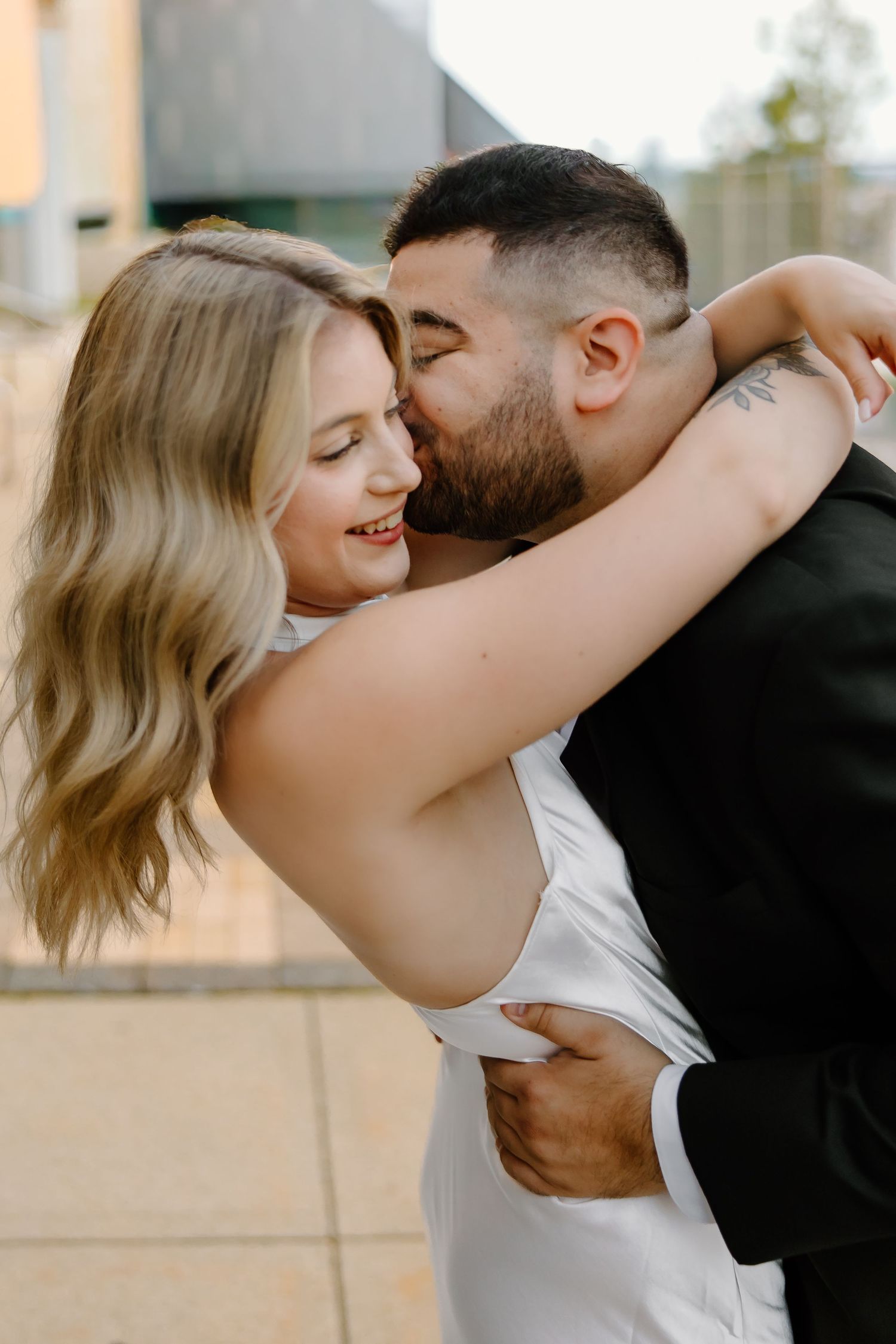 Romantic couple sharing tender moments in an outdoor photoshoot.