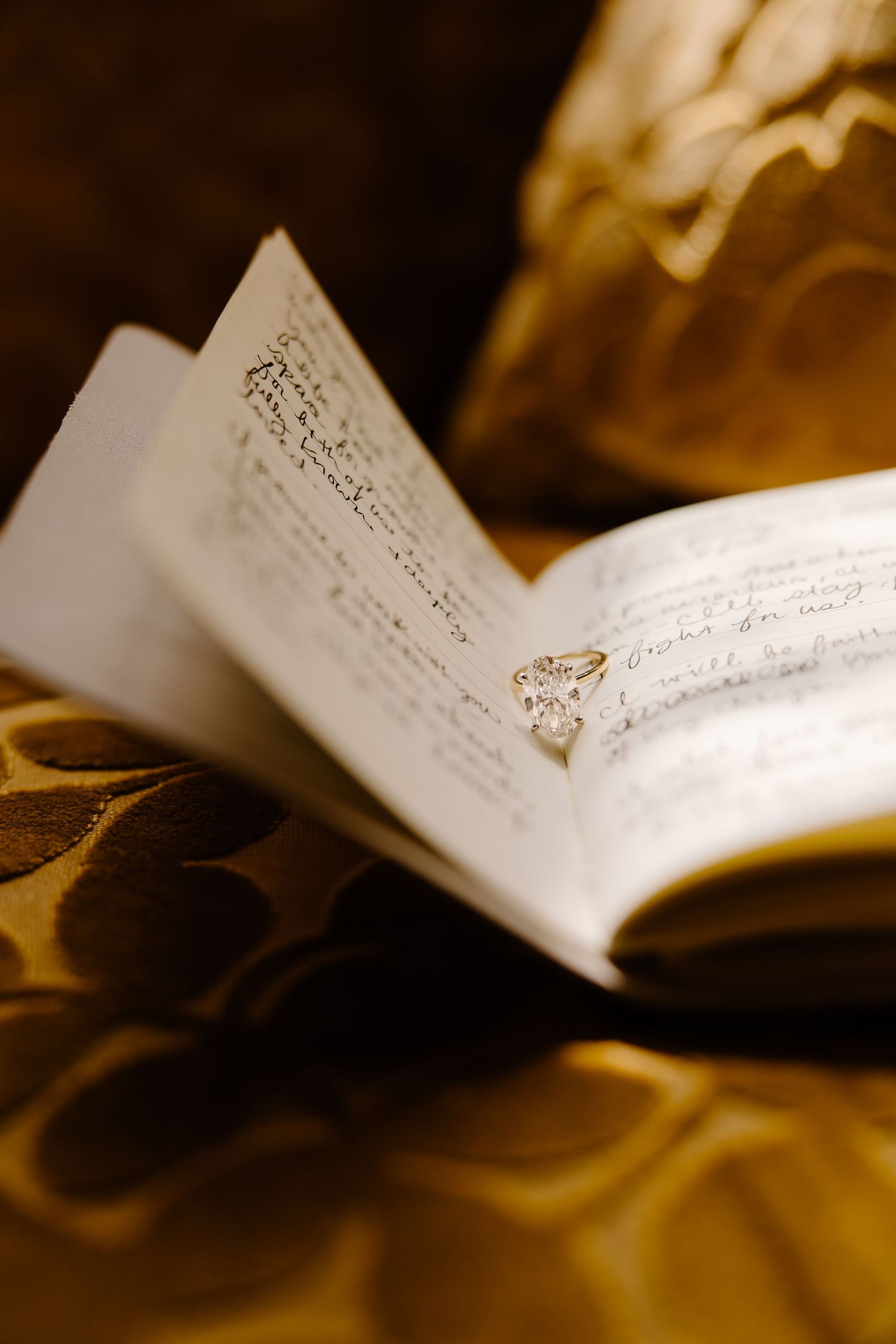 Handwritten wedding details on cream colored paper with soft golden lighting.