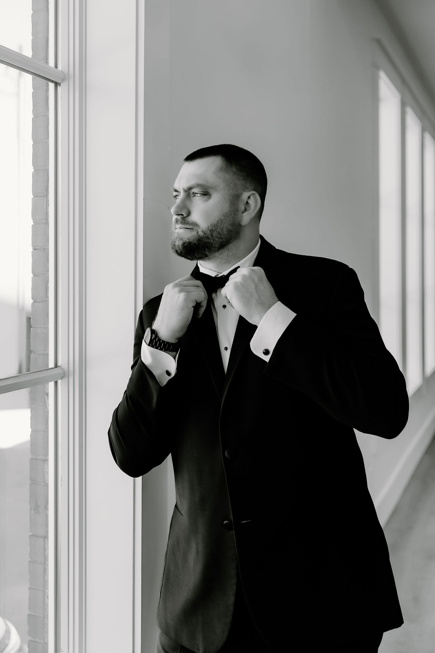 Black and white series of men in formal suits adjusting their ties.