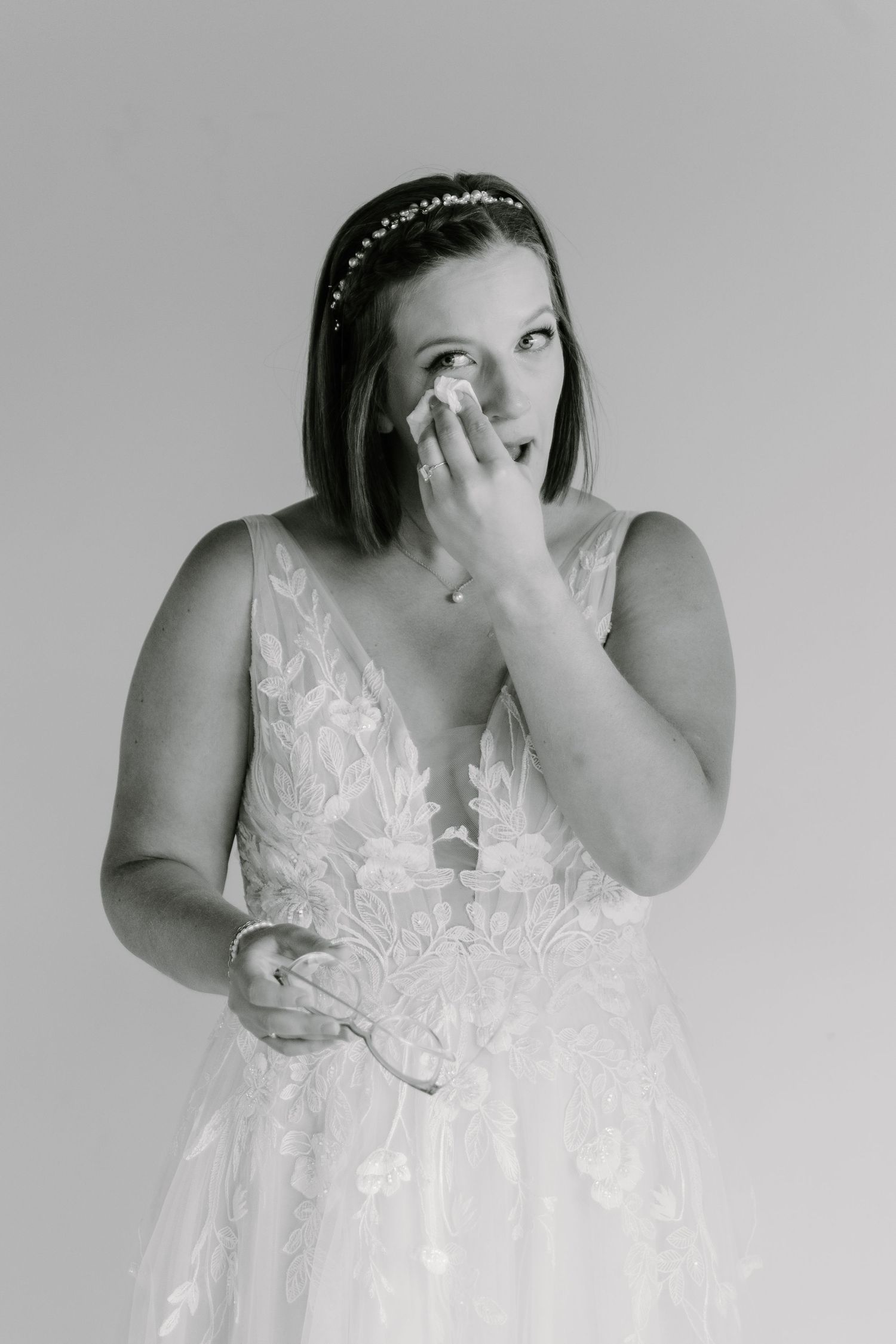Emotional black and white portrait series showing reactions in a white lace dress.