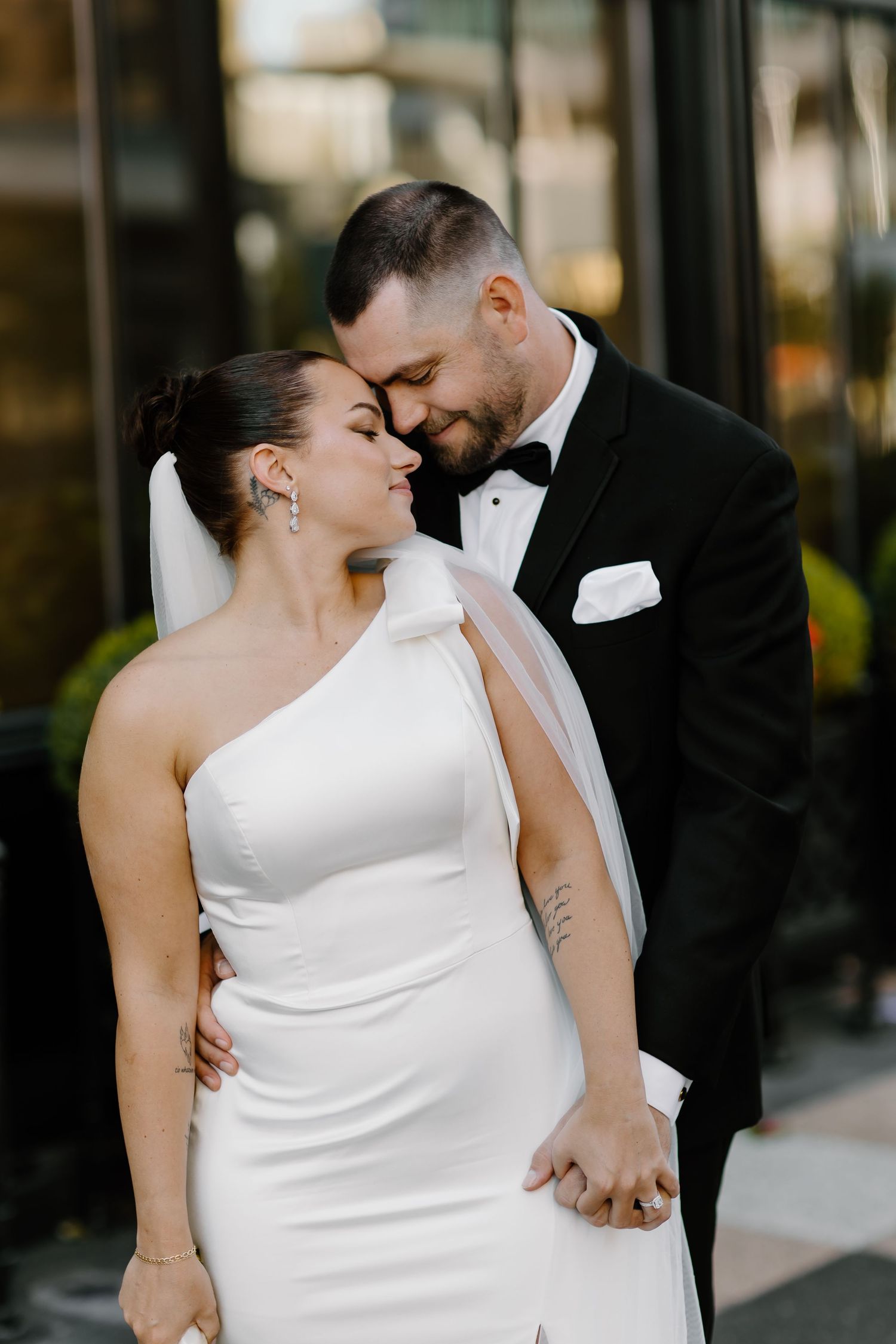 Intimate wedding portraits captured against a dark storefront background.