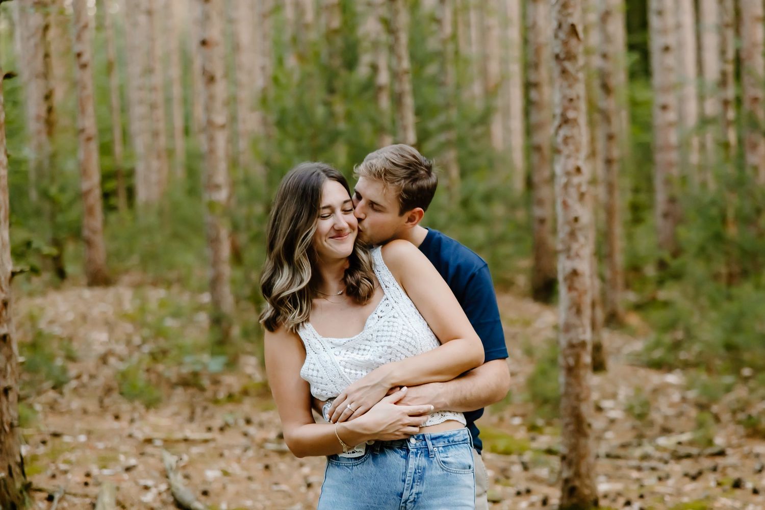 Romantic couple photos in a sunlit forest of tall birch trees.