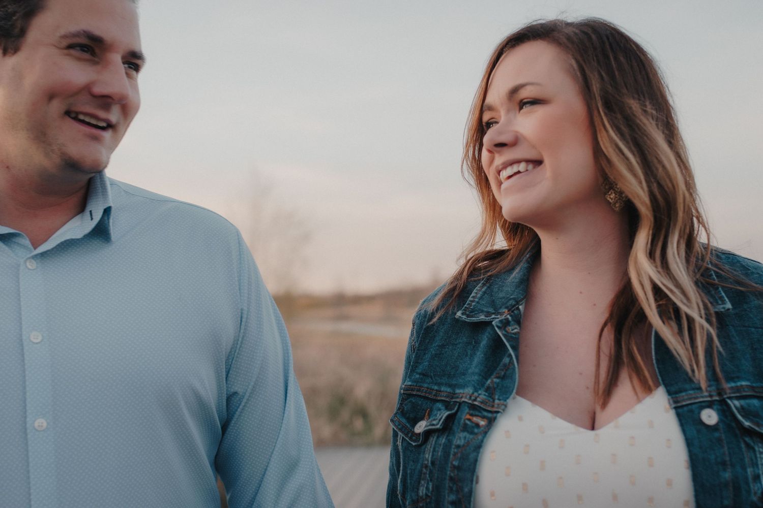 Smiling couple sharing a joyful moment together at sunset outdoors.