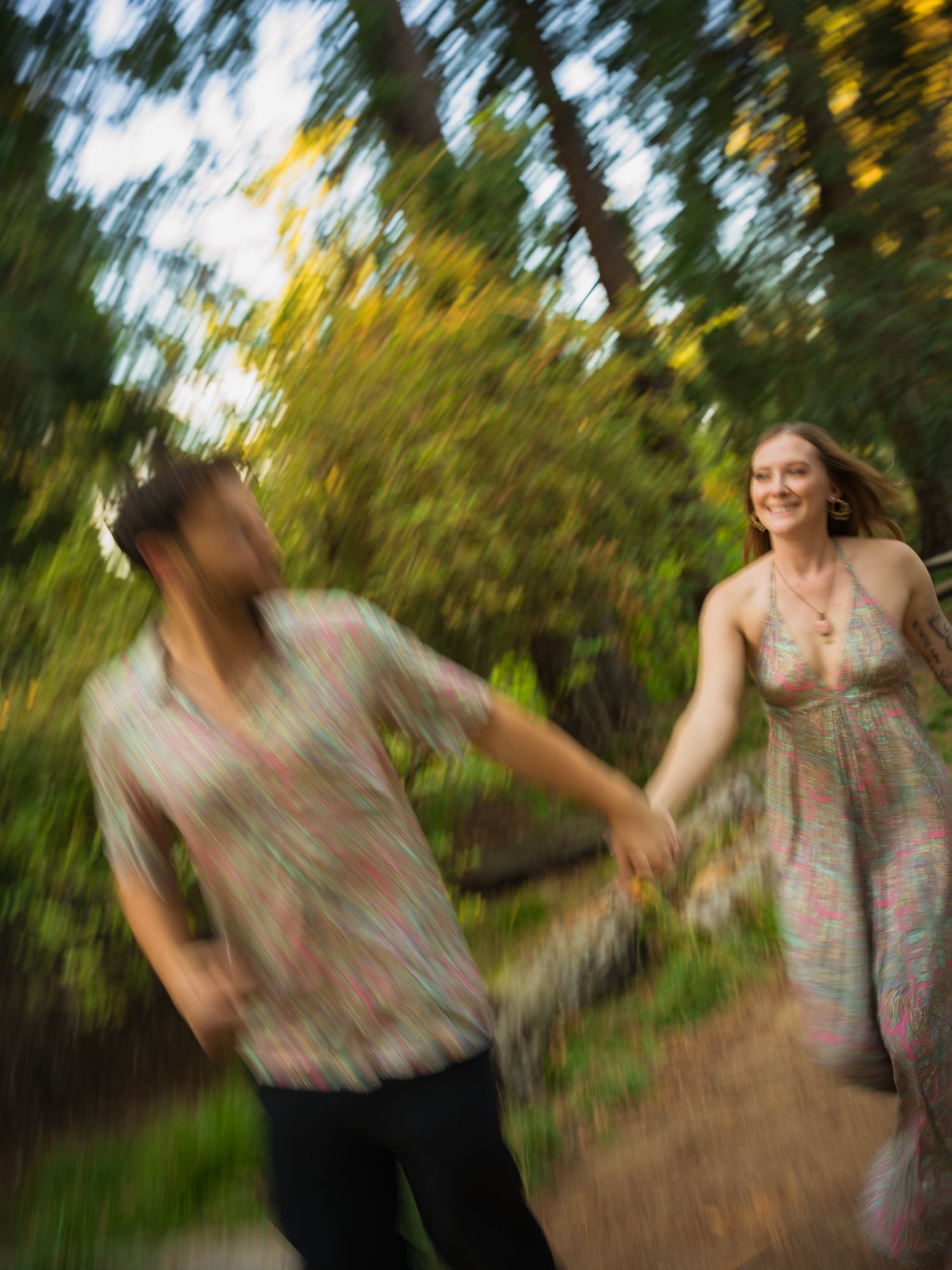 Motion blur photo of couple dancing and spinning in a wooded setting.