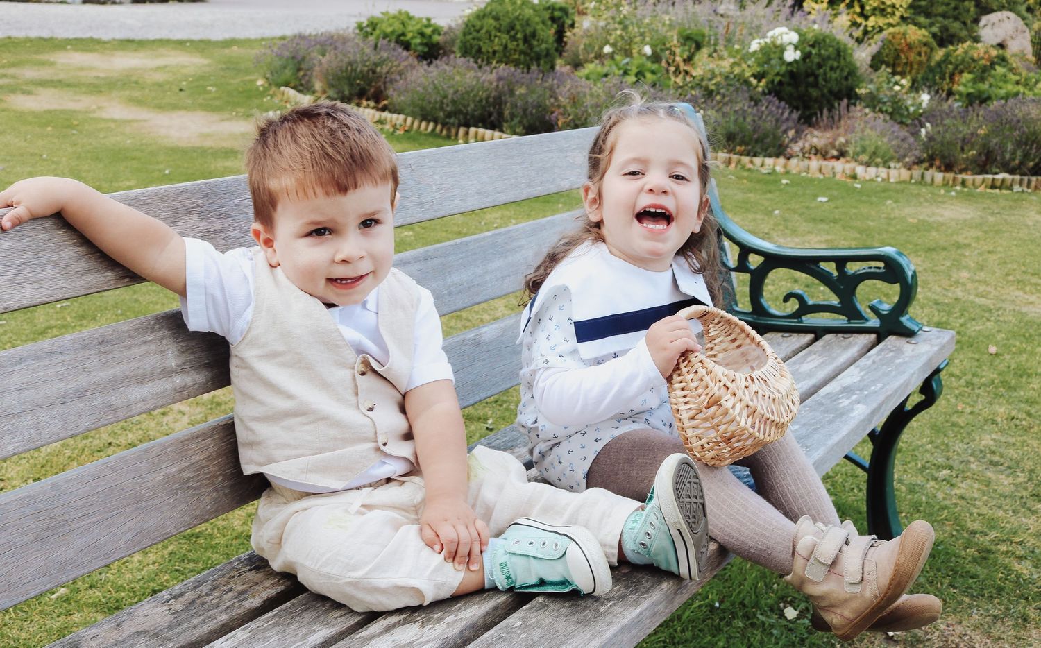 Children enjoying outdoor playtime on wooden benches in a lush garden setting.
