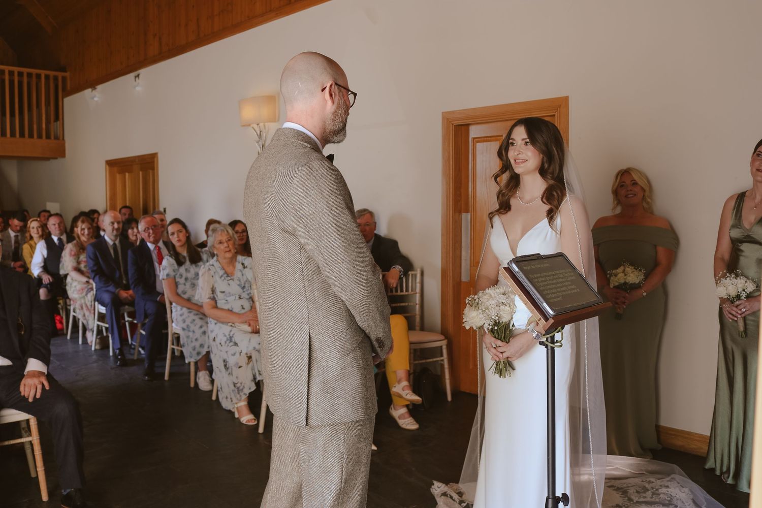 An intimate wedding ceremony moment captured in a rustic venue with wooden walls and natural lighting.