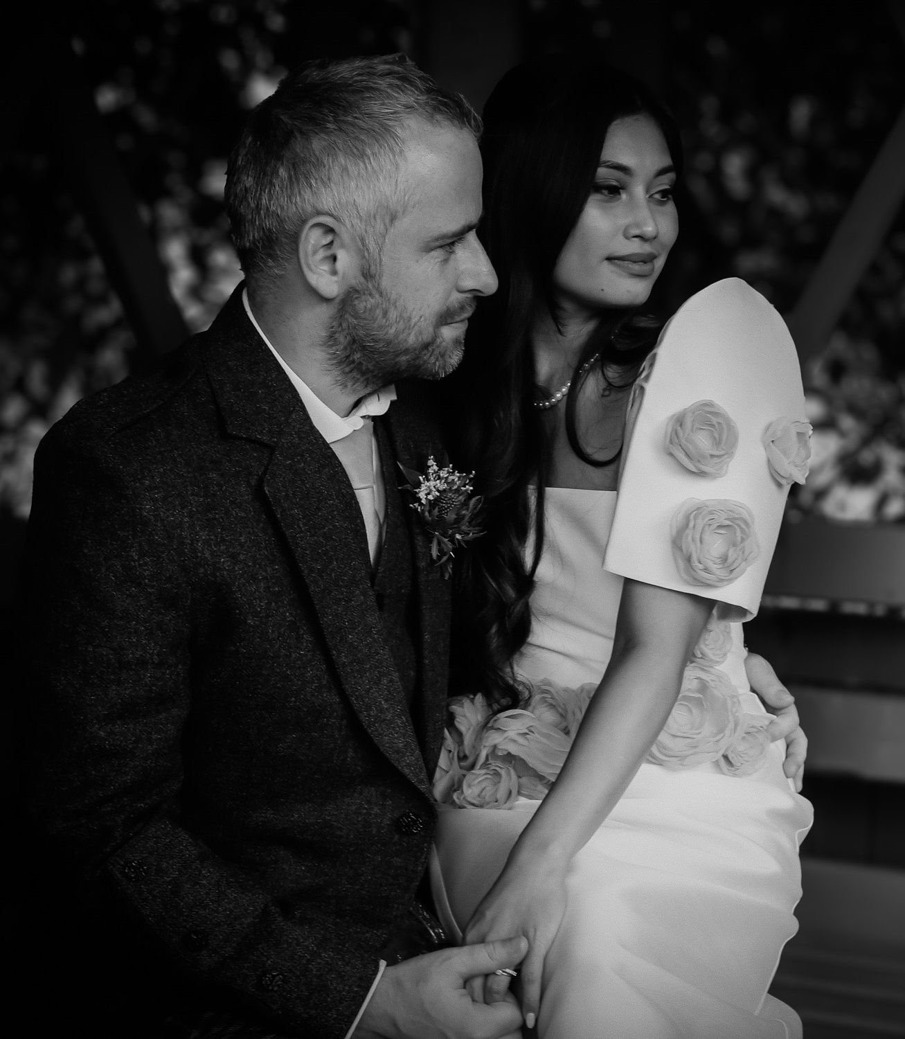 A black and white wedding photo series showing a couple in intimate poses with the bride wearing a sleeveless dress.