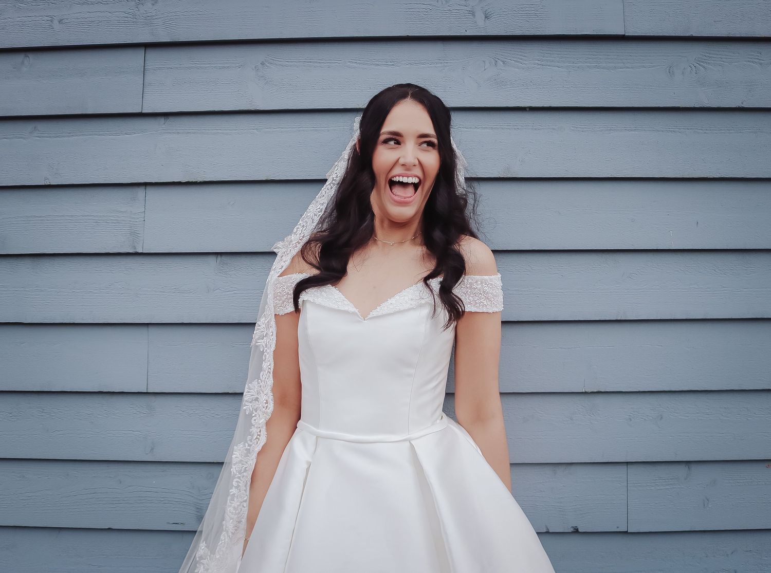 A joyful bride in a white wedding dress twirls and spins across a series of connected photos against a gray wall.