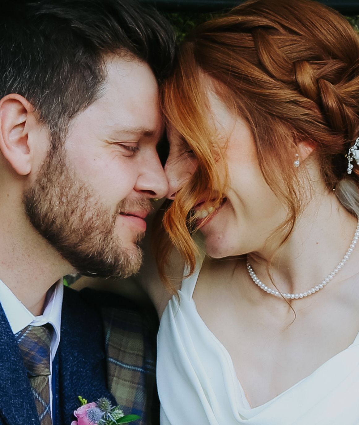 A romantic moment between a couple in wedding attire as they share an intimate close-up embrace.