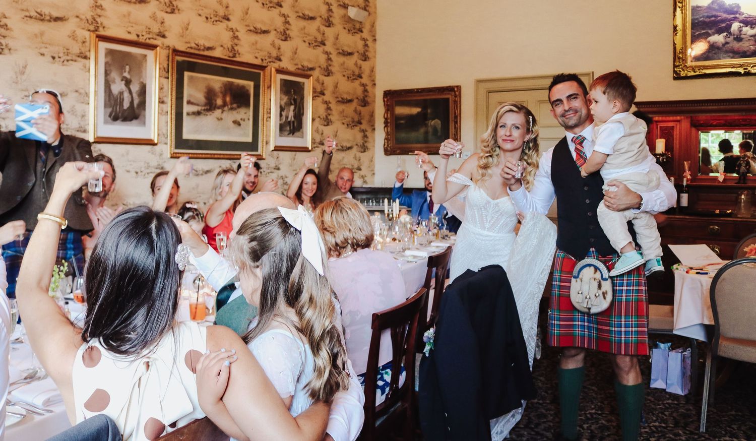 Wedding reception guests celebrating at a traditional Scottish venue with tables set for dinner and party guests enjoying the festivities.