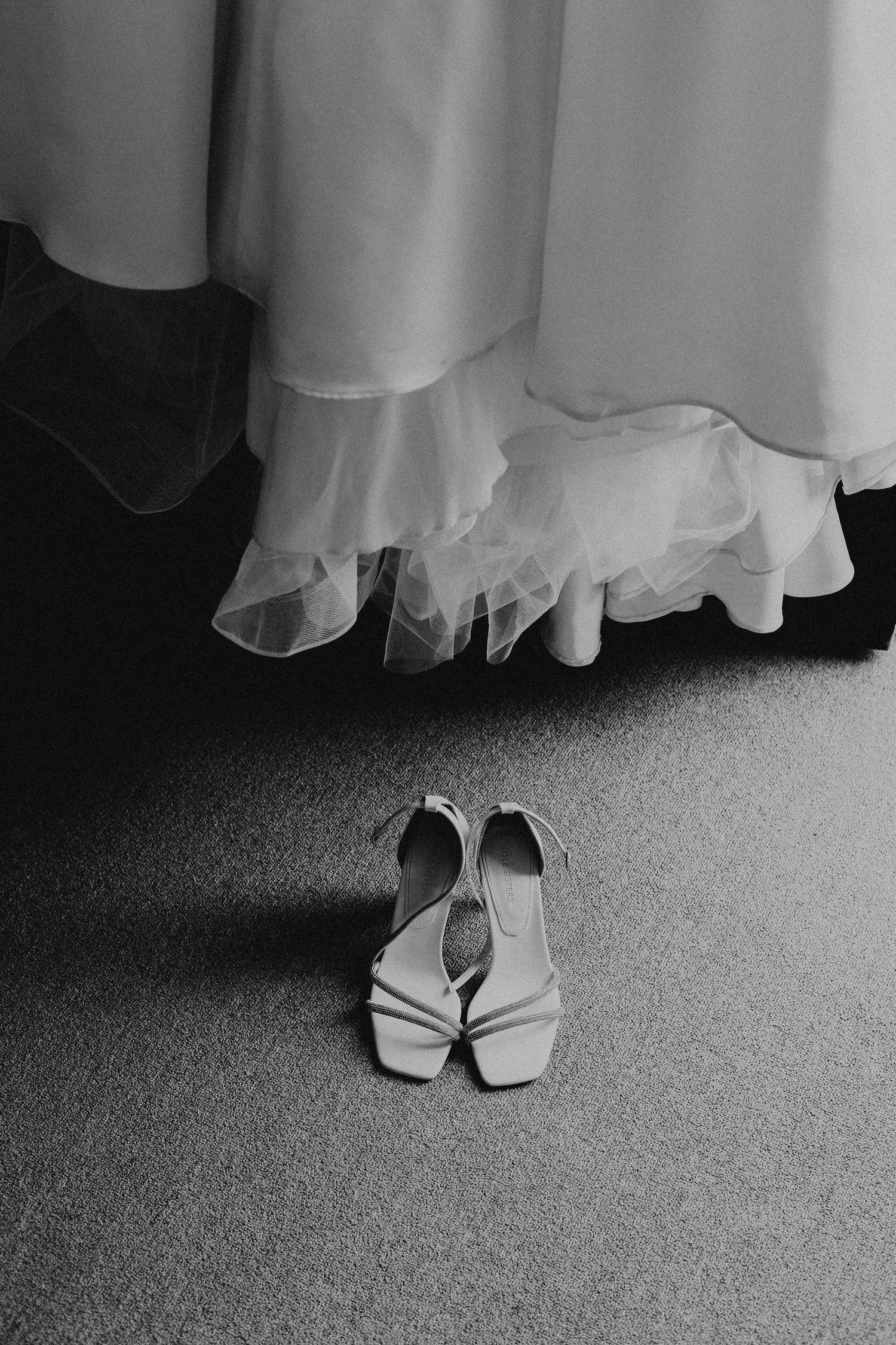 Black and white photo series showing close-up views of elegant white bridal shoes on carpet.