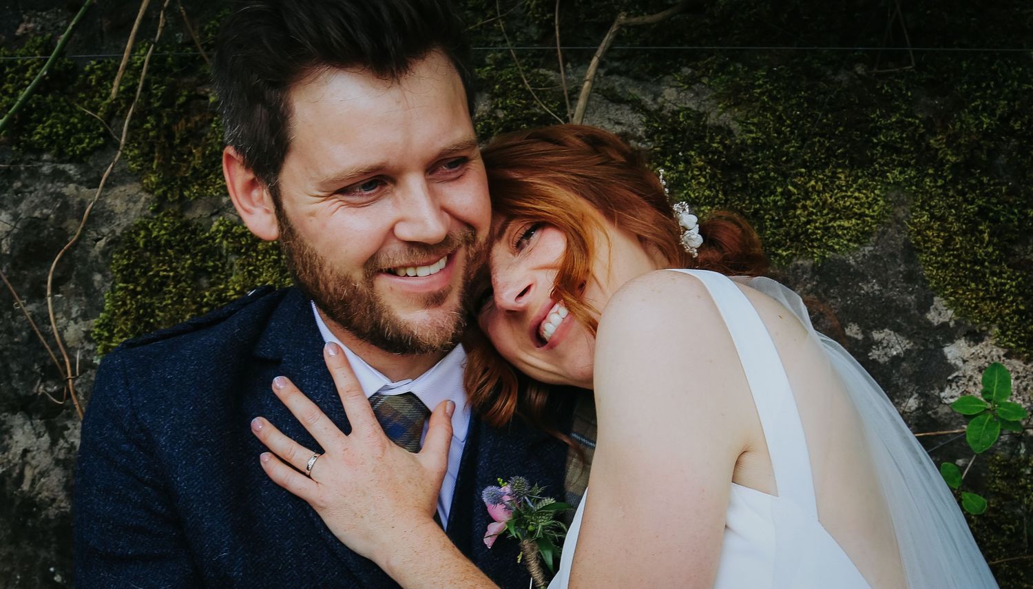 A happy couple shares a joyful moment together outdoors during their wedding celebration.
