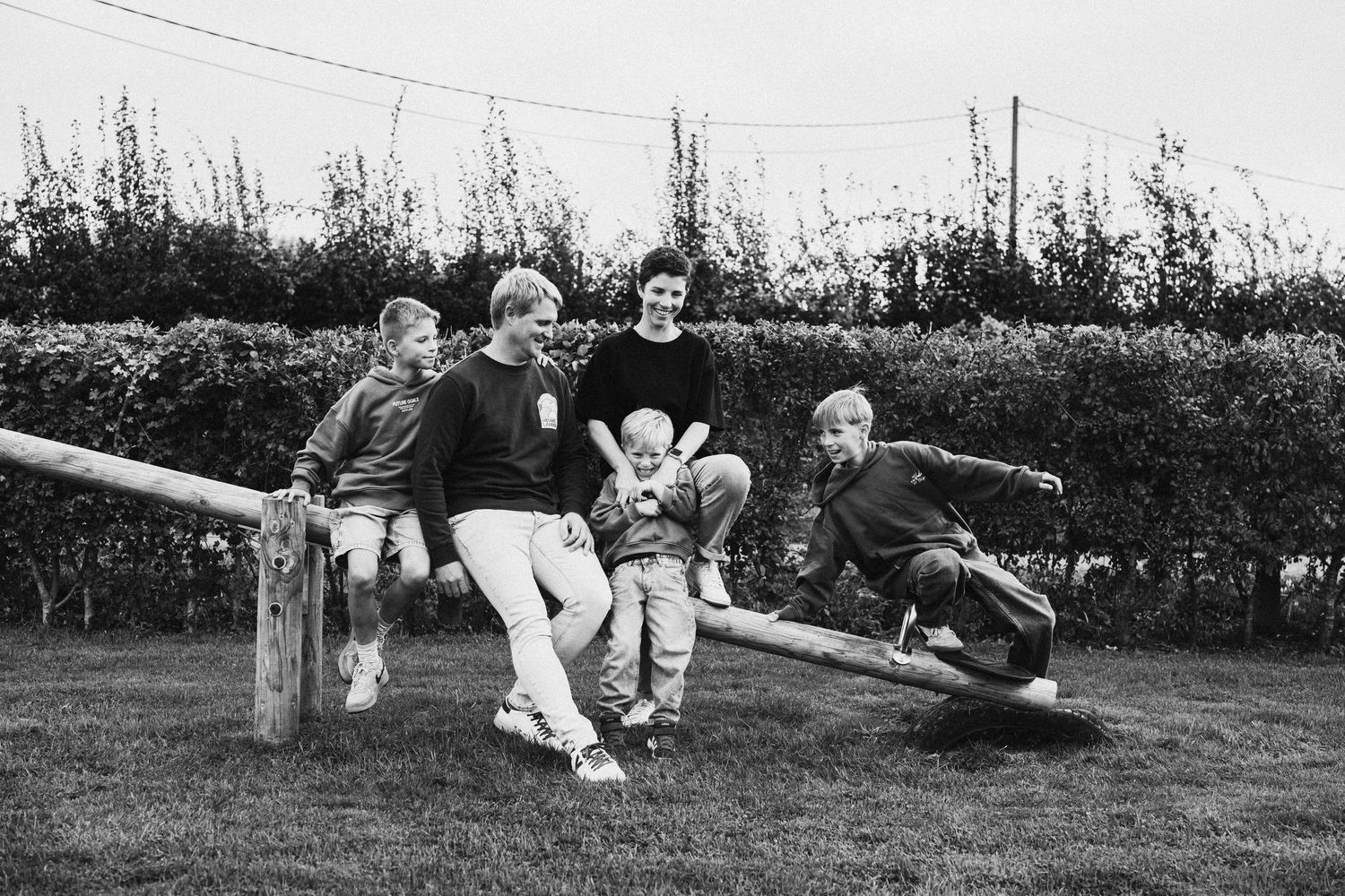 Group lounging casually on grass in black and white photograph sequence.
