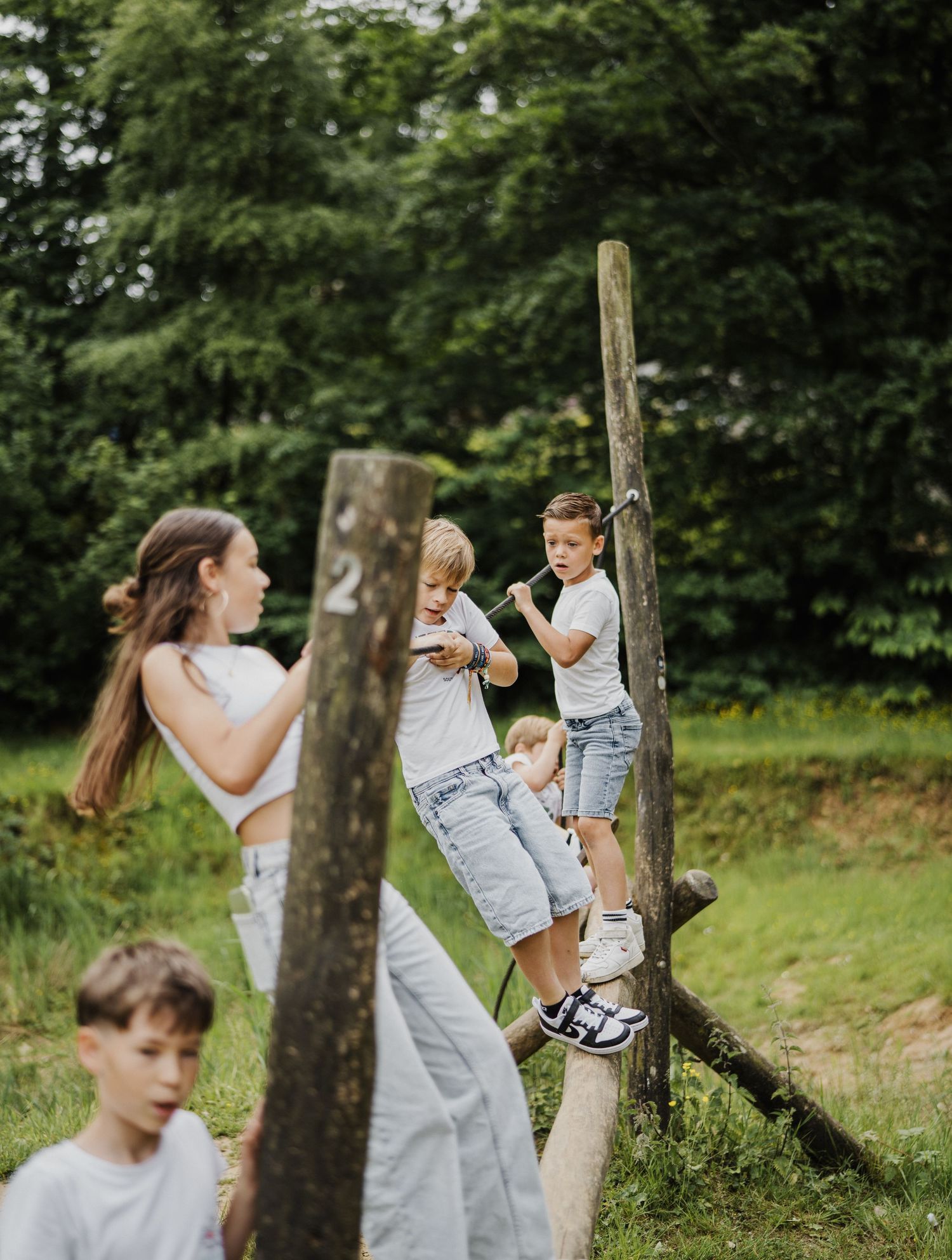 Family playing and running together in a green outdoor setting.