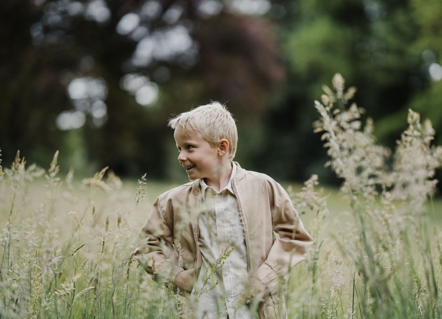 Candid moments captured in a natural grassland setting with soft lighting.