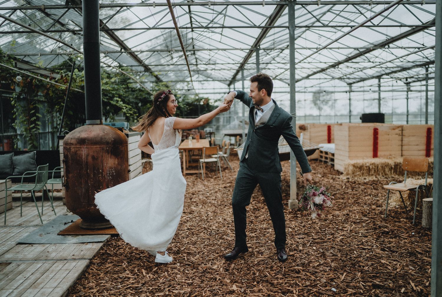 Wedding celebration inside a modern greenhouse with wood chip flooring.