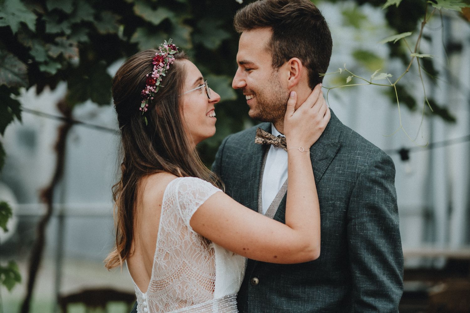 Romantic wedding portraits captured in front of lush green garden setting.