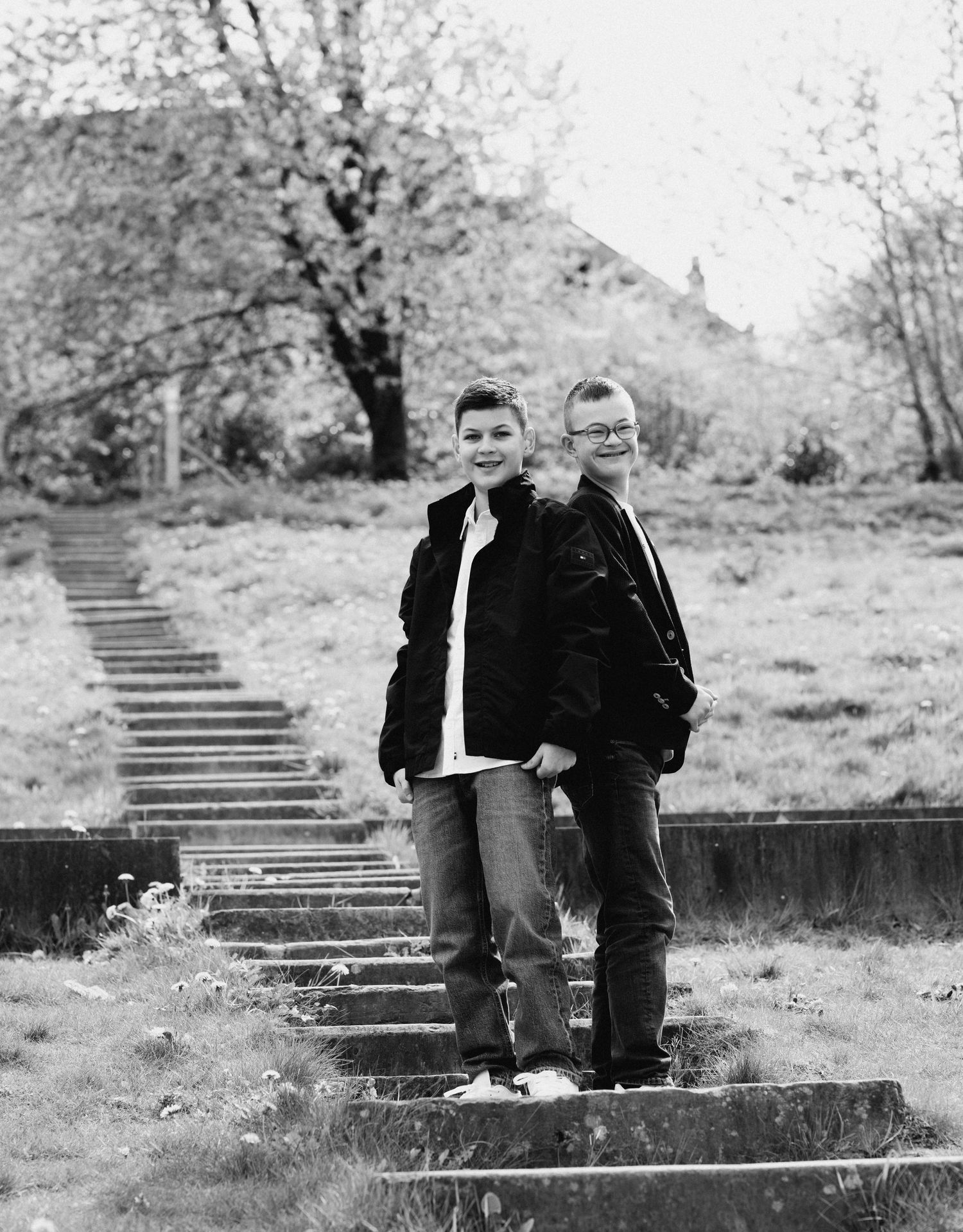 Black and white photographs of people sitting on concrete steps in a natural outdoor setting.