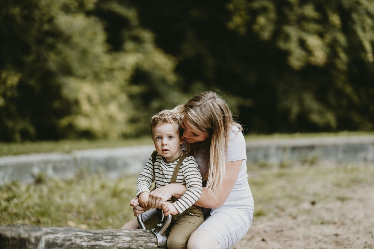 Tender family moment captured outdoors in natural lighting.
