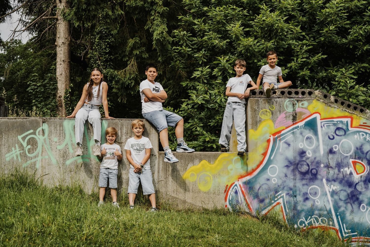 Family posing along colorful graffiti wall in urban setting.