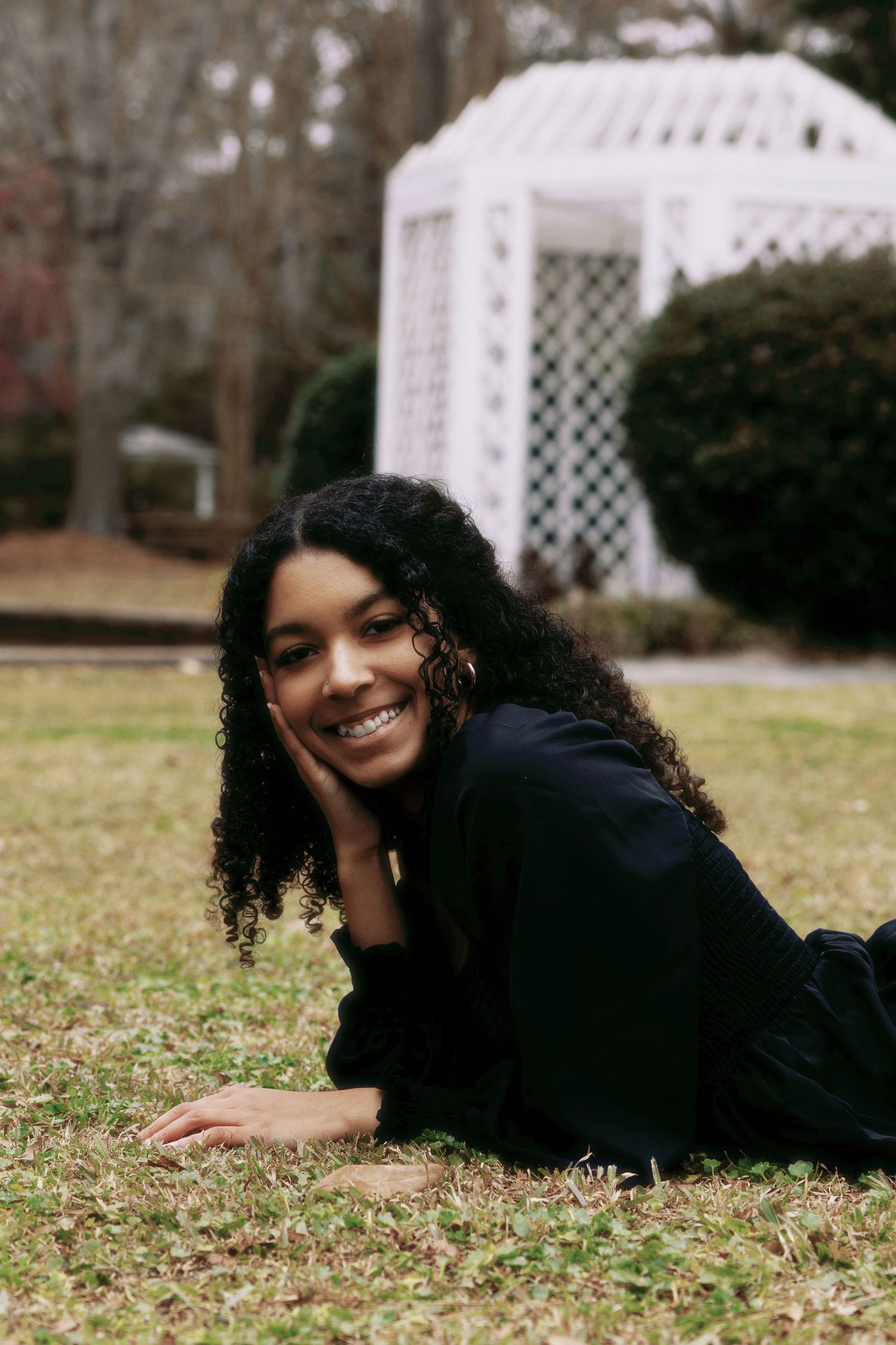 Portrait session on grass with white gazebo in background during autumn.