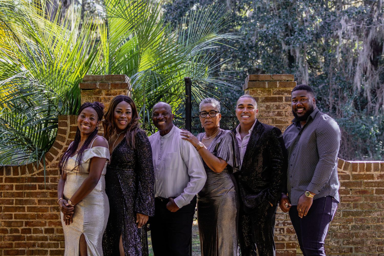 Wedding party group photos taken outdoors against a tropical landscape backdrop.