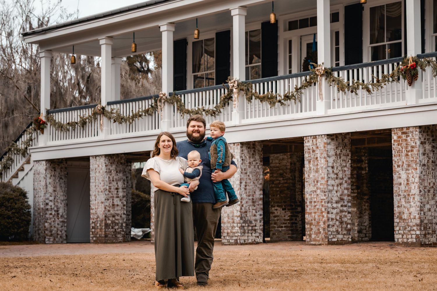 Group photo session in front of a historic white columned plantation house.
