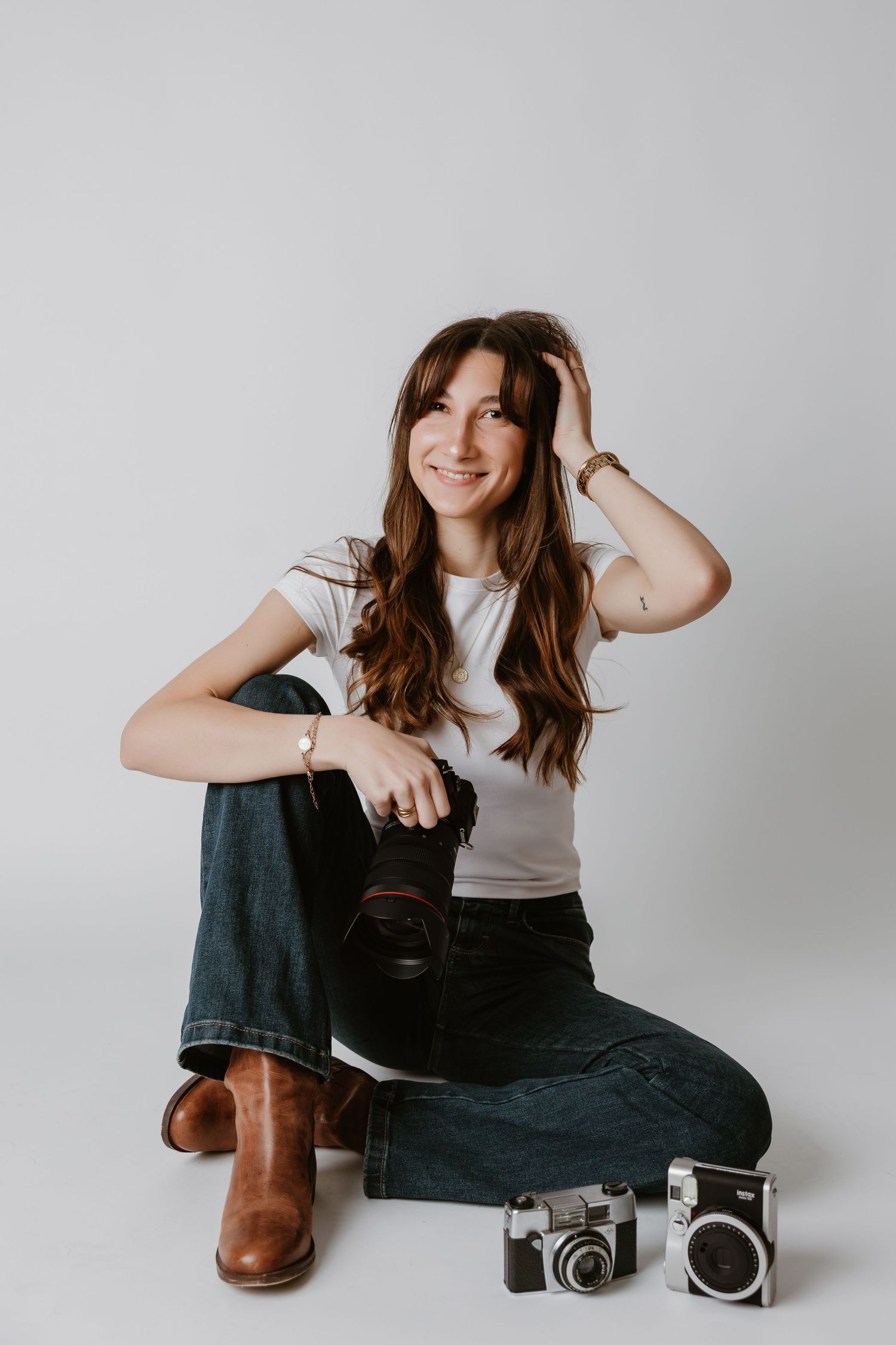 Creative portrait series with vintage camera and boots against white backdrop.