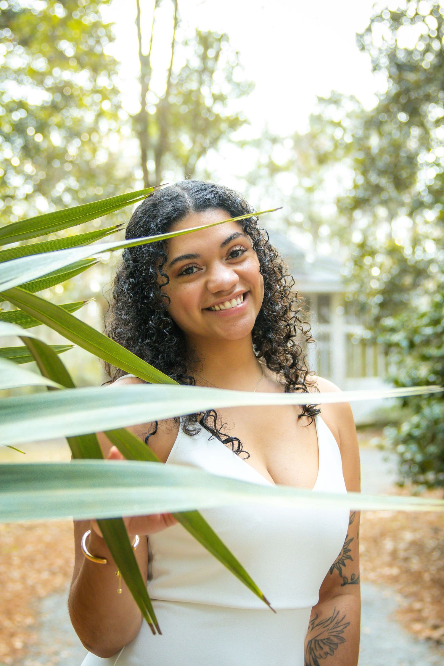 Tropical outdoor portrait session with palm fronds and natural lighting.