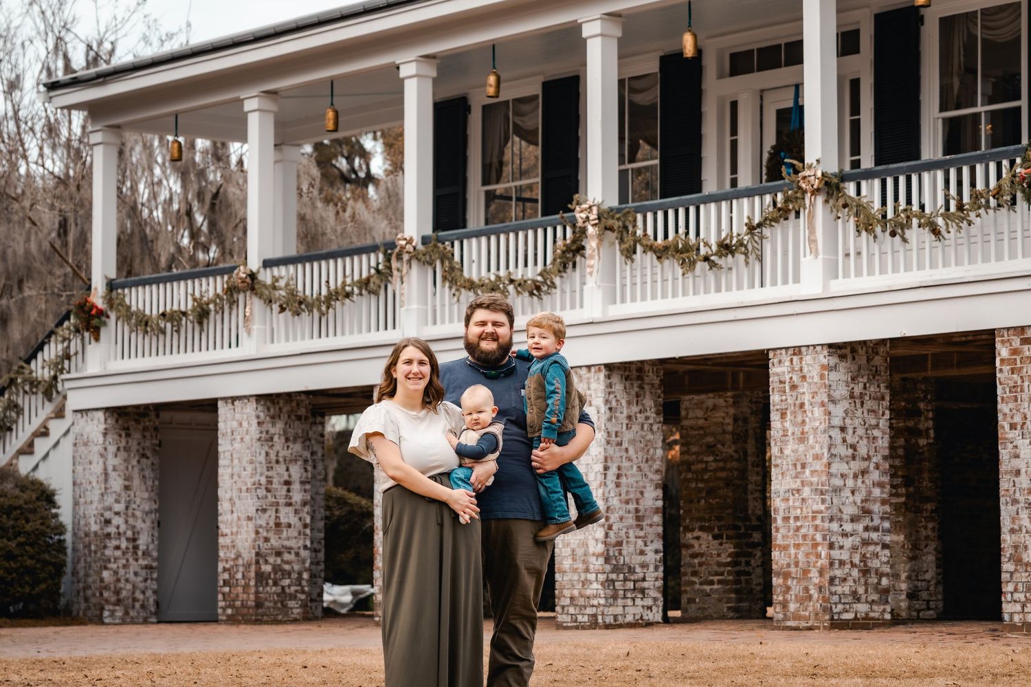 White columned southern mansion exterior with holiday garland decorations.