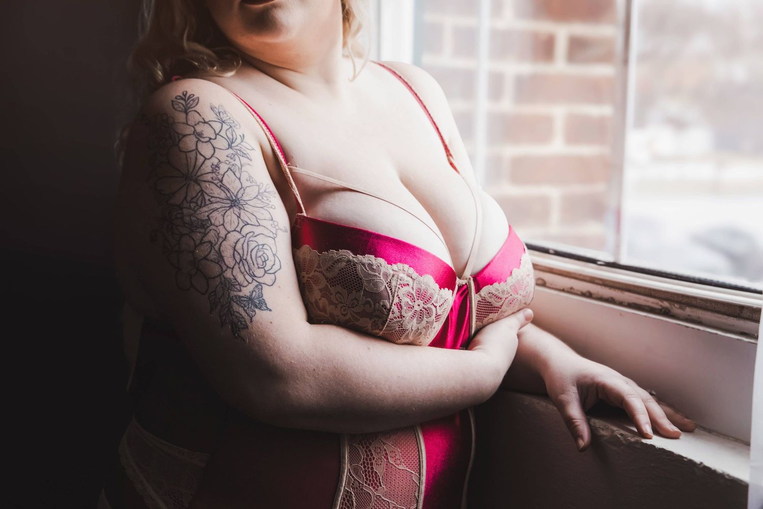Intimate boudoir photography – close up bust with plus sized sensual pose, natural light and soft shadows in York, PA studio