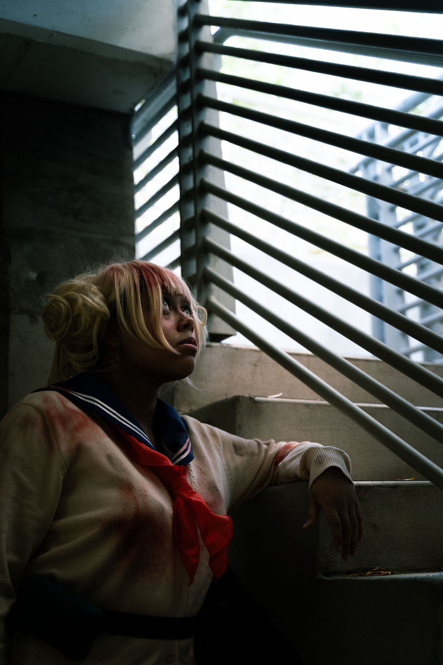 A cinematic sequence showing a person in a white and red sailor uniform reclining near venetian blinds in moody lighting.