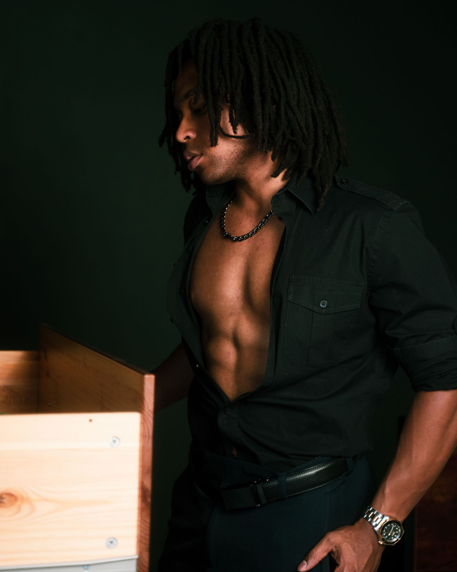 Artistic portrait series in low light showing dramatic shadows and formal attire.